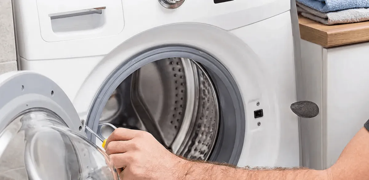 Handyman repairing a front-load washing machine and inspecting the drum in Pasadena, CA