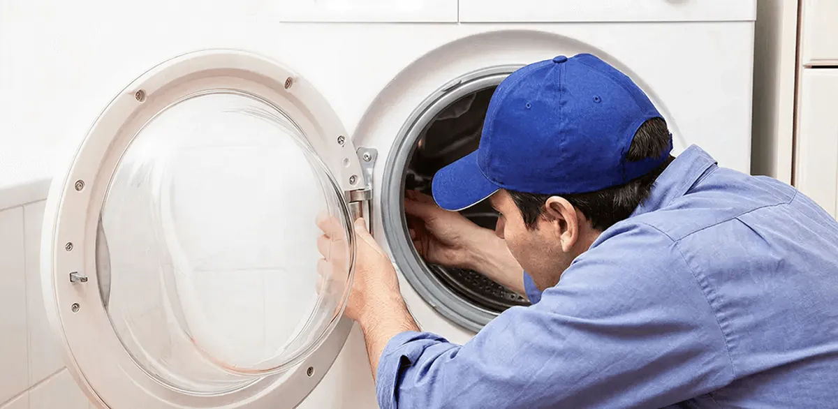 Washing machine repair handyman inspecting a front-load washer drum in Pasadena, CA